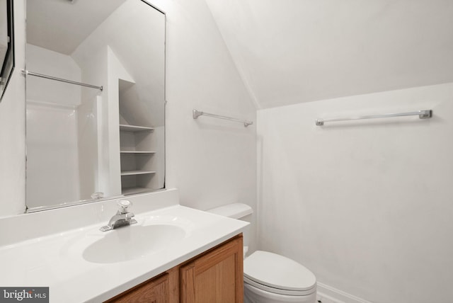 bathroom with vanity, toilet, and lofted ceiling