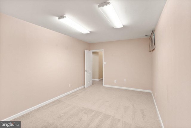 empty room with baseboards and light colored carpet