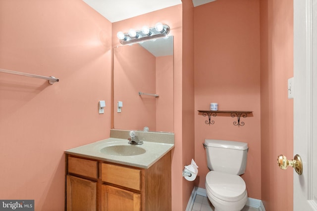 half bath with toilet, tile patterned floors, and vanity