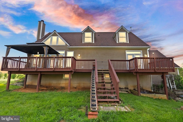 back of property featuring a deck, a yard, stairway, and a chimney