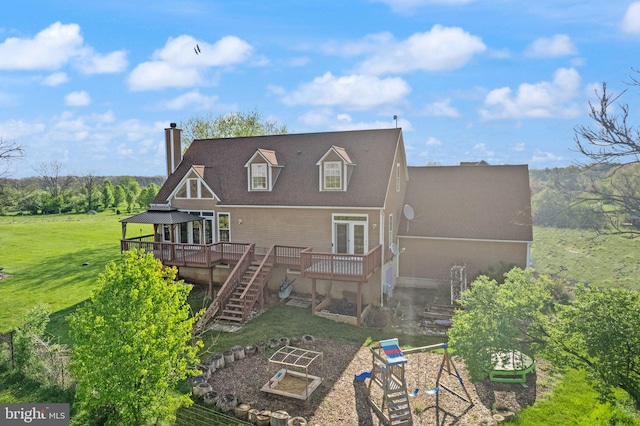 rear view of house featuring a wooden deck, stairway, a chimney, a garden, and a yard
