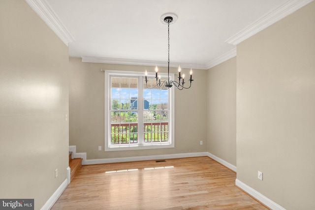 unfurnished dining area with crown molding, baseboards, wood finished floors, and a chandelier
