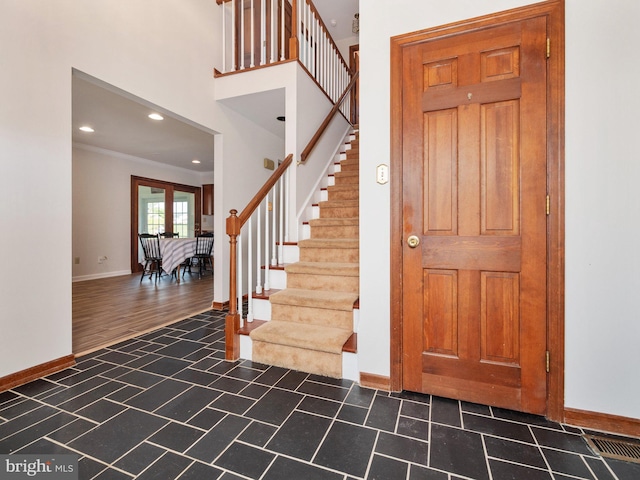 foyer with baseboards, ornamental molding, stairs, and recessed lighting