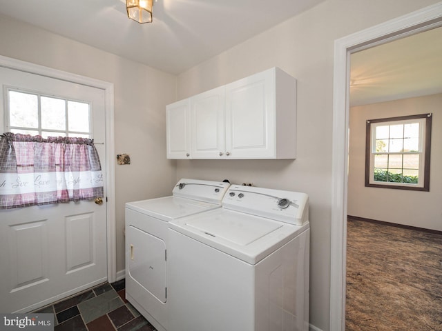 laundry room featuring baseboards, cabinet space, and washing machine and clothes dryer