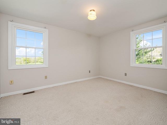 carpeted spare room with baseboards and visible vents