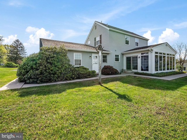 back of house featuring a sunroom and a yard