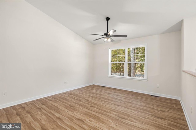 empty room with ceiling fan, baseboards, and light wood finished floors