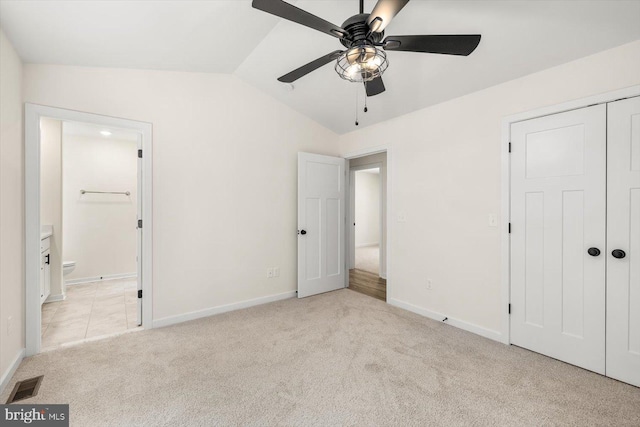 unfurnished bedroom with baseboards, carpet, lofted ceiling, and visible vents