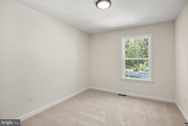 empty room with baseboards, carpet flooring, and visible vents