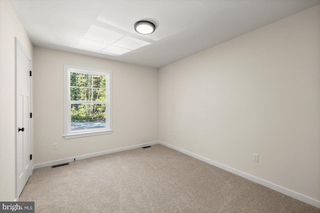 unfurnished room with baseboards, light carpet, and visible vents