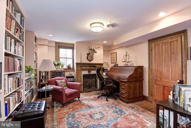 office space with recessed lighting, wood finished floors, and a fireplace