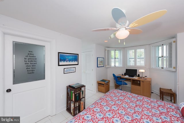 bedroom with baseboards, a ceiling fan, light tile patterned flooring, and a closet