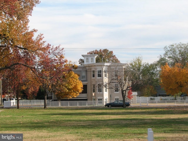 rear view of house with a lawn and fence