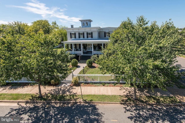 view of front of house with covered porch, stairway, and a fenced front yard