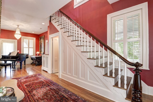 staircase featuring recessed lighting, baseboards, wood finished floors, and a chandelier