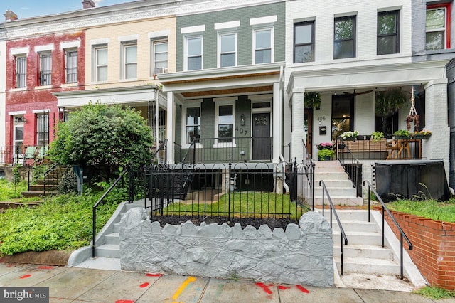 407 16th St SE, Washington, DC 20003 - view of front of house featuring stairs, covered porch, brick siding, and a fenced front yard