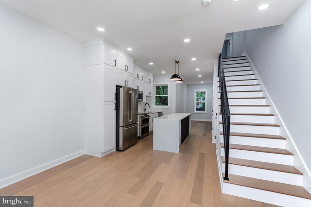 407 16th St SE, Washington, DC 20003 - kitchen featuring stainless steel appliances, a center island, white cabinetry, light wood-type flooring, and recessed lighting