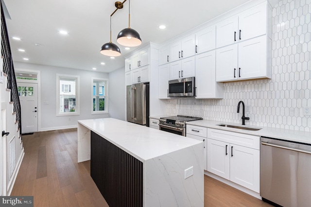 407 16th St SE, Washington, DC 20003 - kitchen featuring appliances with stainless steel finishes, a sink, tasteful backsplash, white cabinetry, and a center island