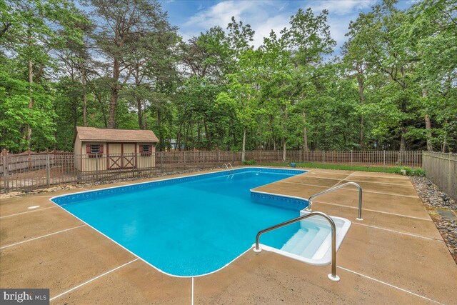 8 Winchester Ct, Tabernacle, NJ 08088 - view of swimming pool featuring a patio area, an outdoor structure, and view of wooded area