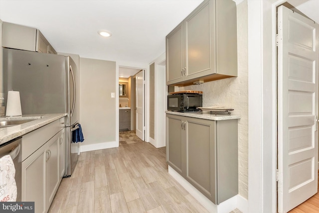 kitchen featuring gray cabinetry, dishwasher, light wood-type flooring, and baseboards