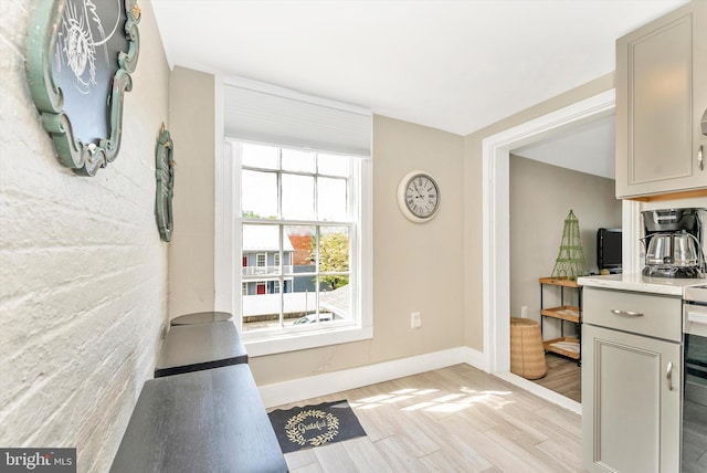 doorway to outside with baseboards and light wood-style floors