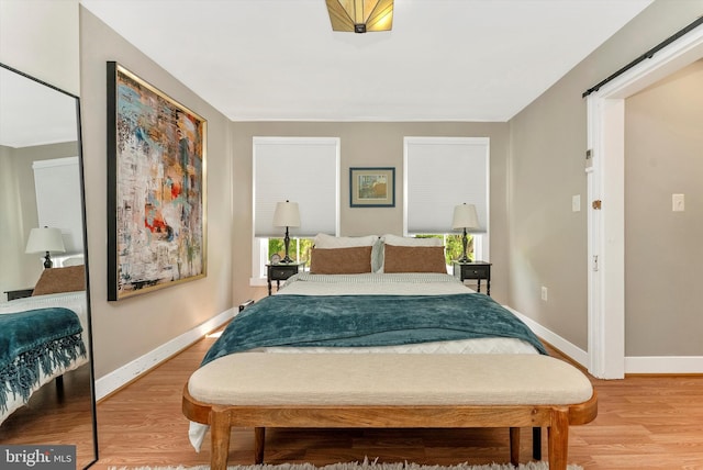 bedroom featuring baseboards and light wood finished floors