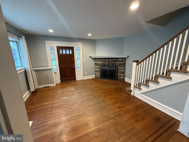 entrance foyer with stairs, wood finished floors, a fireplace, baseboards, and recessed lighting