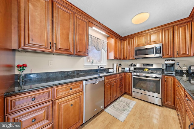 412 Prospect Ave, Pine Beach, NJ 08741 - kitchen with stainless steel appliances, brown cabinetry, a sink, and light wood-style floors