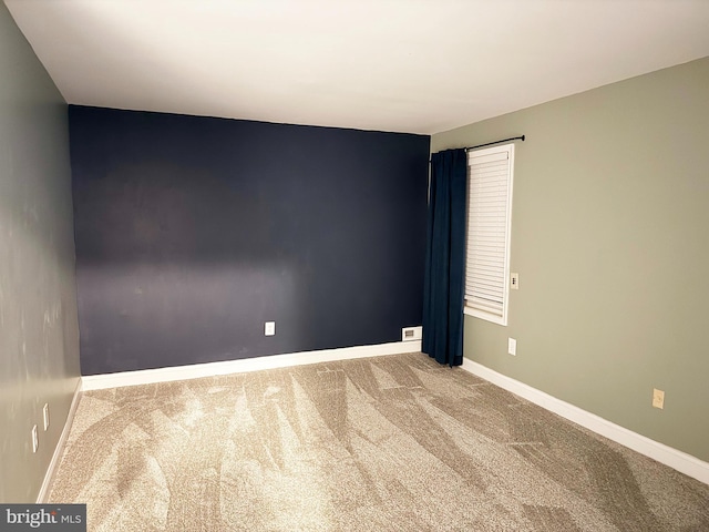 carpeted empty room with baseboards
