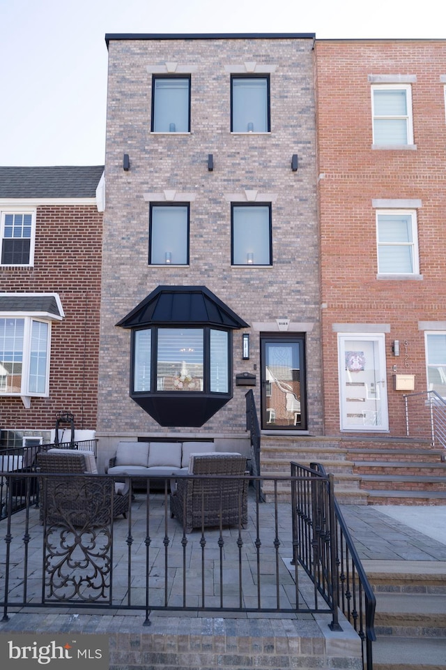 view of front facade featuring brick siding and outdoor lounge area