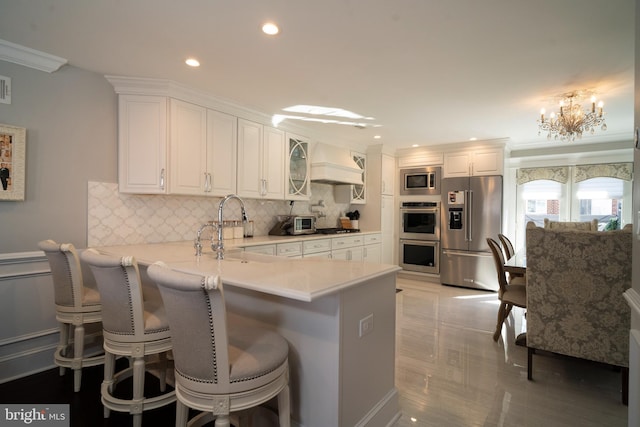 kitchen with custom exhaust hood, stainless steel appliances, a peninsula, and white cabinetry