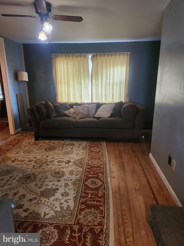 living room with baseboards, a ceiling fan, and wood finished floors