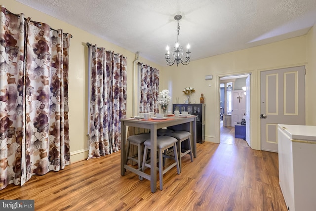 731 Locust St, Columbia, PA 17512 - dining area featuring baseboards, a textured ceiling, light wood-style flooring, and a chandelier