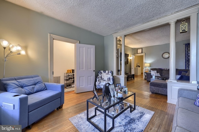 731 Locust St, Columbia, PA 17512 - living area with radiator, wood-type flooring, ornate columns, and a textured ceiling