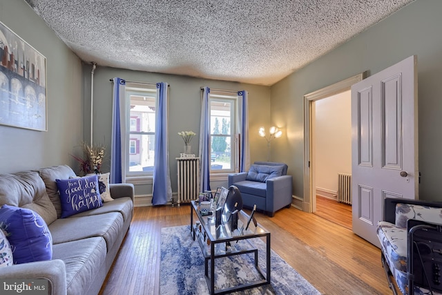 731 Locust St, Columbia, PA 17512 - living area with a textured ceiling, radiator heating unit, and light wood-style floors