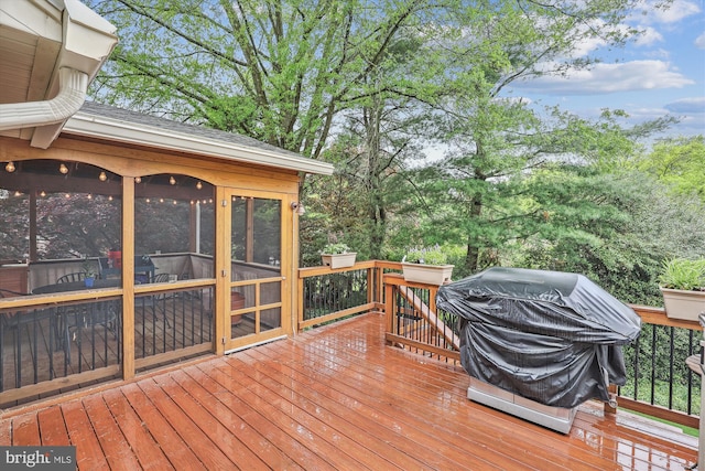 wooden terrace featuring a sunroom and area for grilling