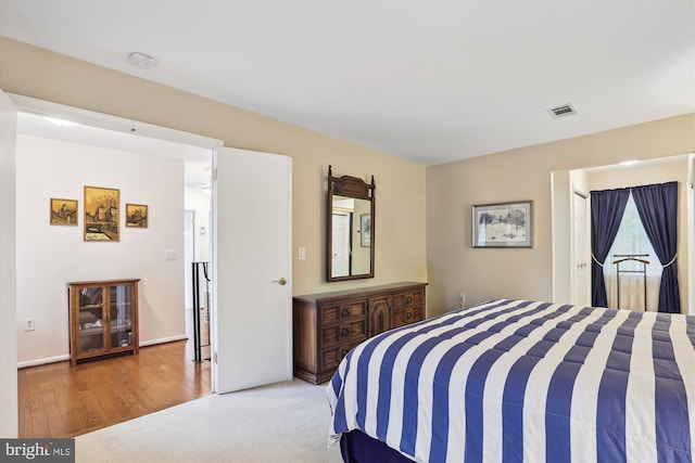 bedroom featuring visible vents and wood finished floors
