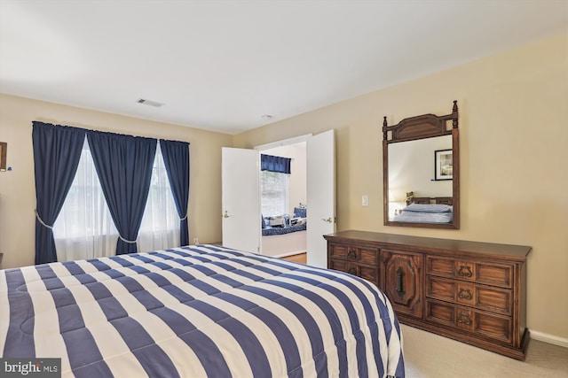 bedroom featuring light colored carpet and visible vents