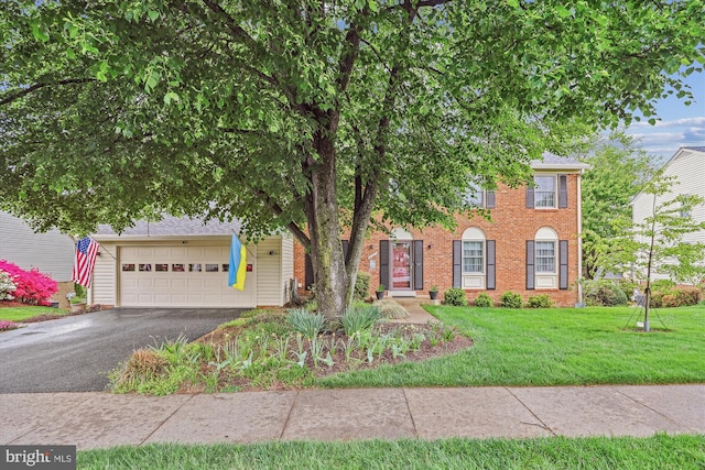 view of front of property featuring brick siding, a front lawn, and aphalt driveway