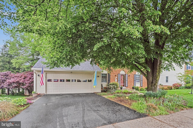 obstructed view of property featuring brick siding, aphalt driveway, roof with shingles, and a garage