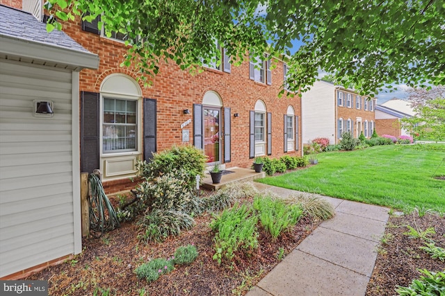 colonial inspired home with a front yard and brick siding