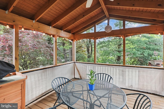 sunroom / solarium with a ceiling fan, outdoor dining space, and beamed ceiling