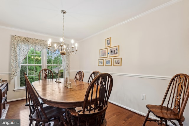dining area featuring baseboards, ornamental molding, wood finished floors, and a notable chandelier
