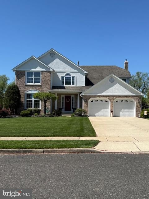 craftsman inspired home with a garage, a chimney, driveway, and a front lawn