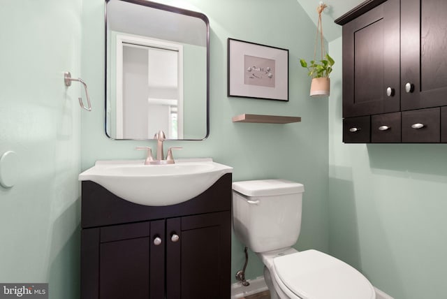 bathroom featuring vanity, baseboards, and toilet