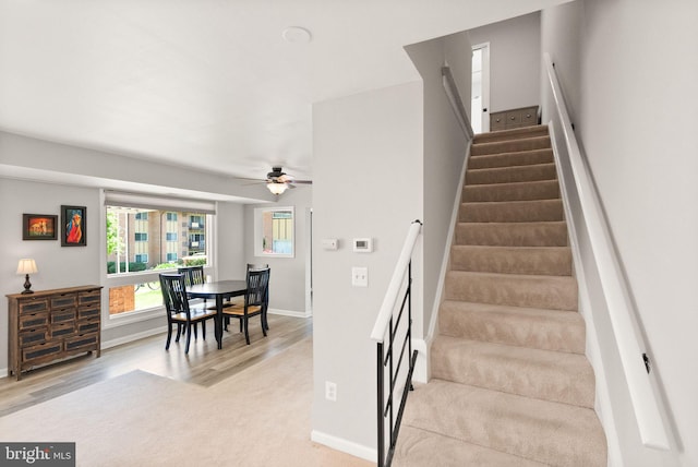 stairway with baseboards, a ceiling fan, and wood finished floors