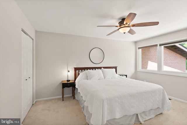 bedroom featuring baseboards, a ceiling fan, a closet, and light carpet