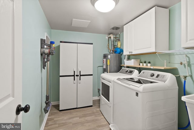 laundry room with cabinet space, independent washer and dryer, light wood finished floors, water heater, and visible vents