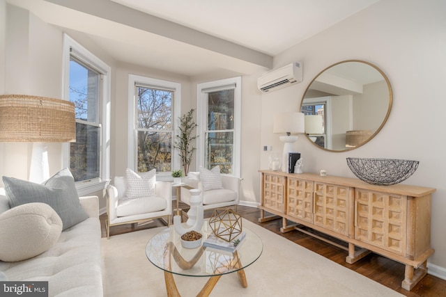 living area featuring baseboards, a wall mounted AC, and wood finished floors