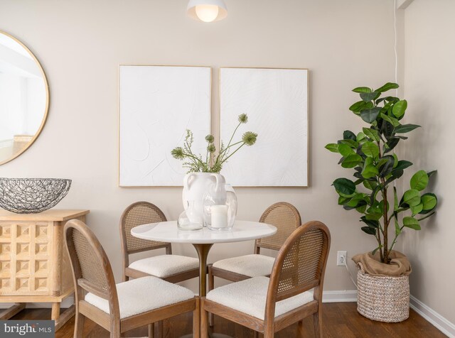 dining space featuring baseboards and wood finished floors